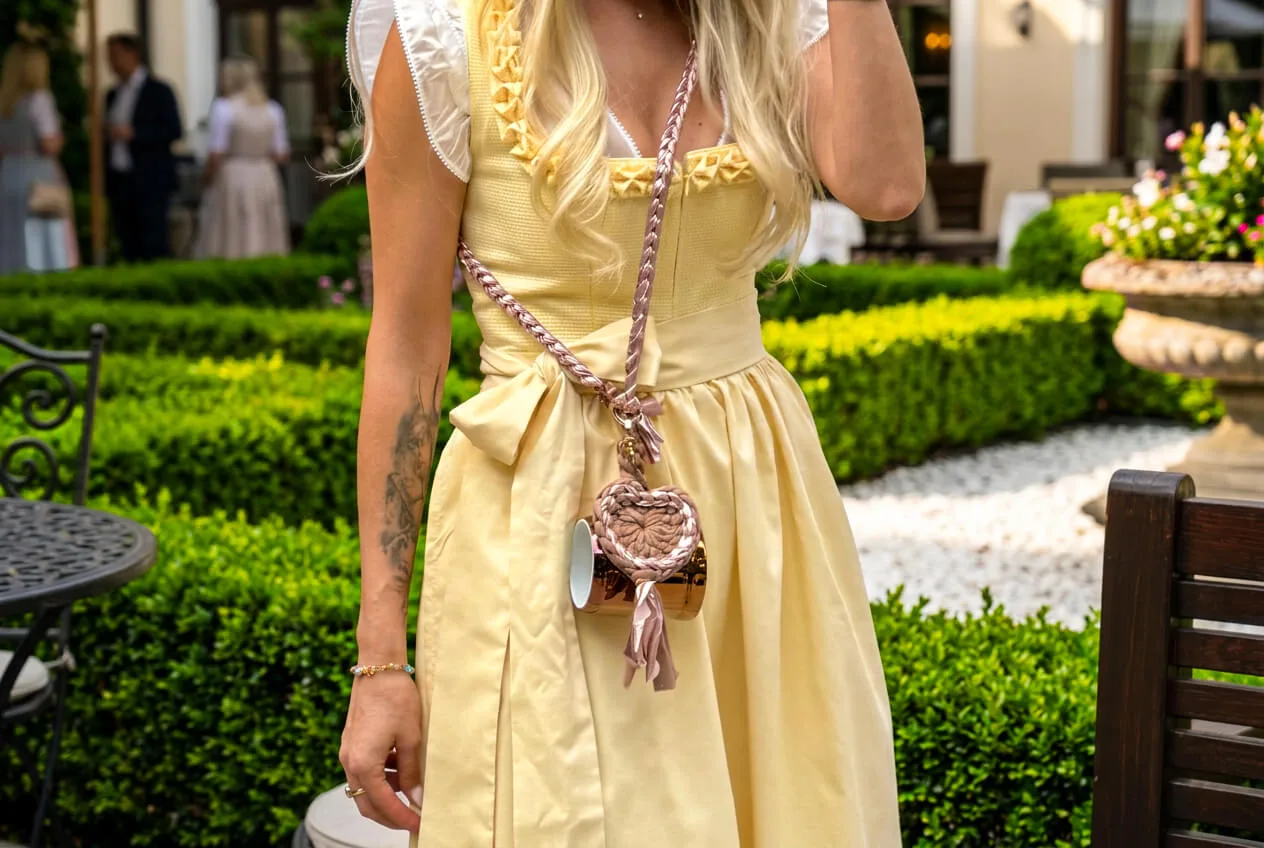 Roségold LOGOKRUG Krügerl mit pinkem Loopheart am Dirndl getragen